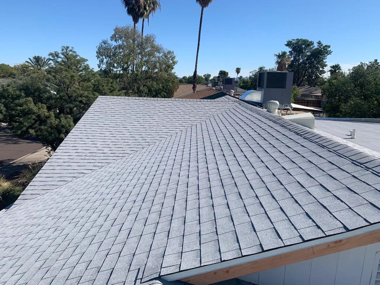 Wide aerial view of a completed shingle roof among palms, by A1 Roofing Solutions